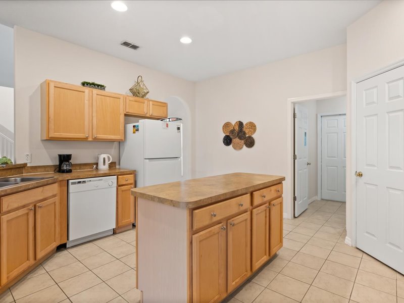 Kitchen island with the fridge and dishwasher in view