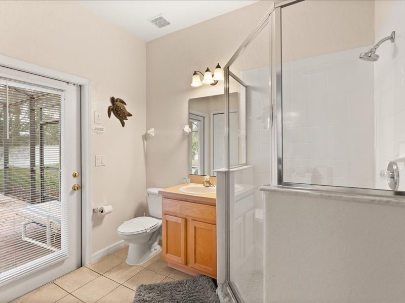 Bathroom # 2  with a sink, toilet, walk in shower and direct access to the pool area