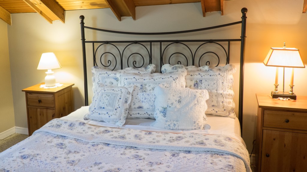 Queen bed in large bedroom with set of twins at other end - Artist's Cottage - Niagara-on-the-Lake