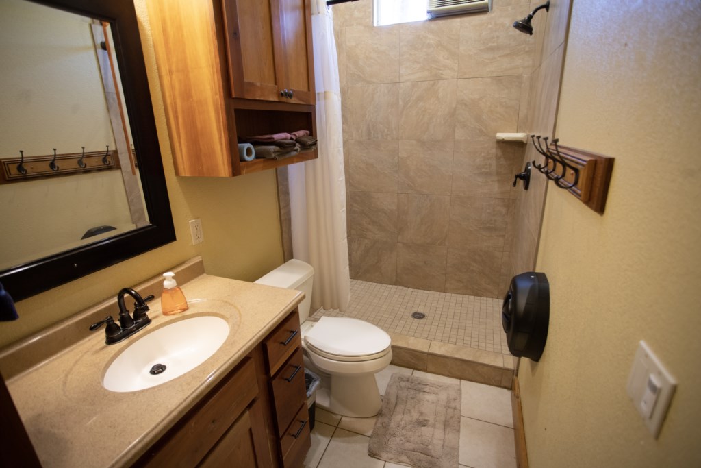 Clean & functional restrooms with a shower, toilet and sink.