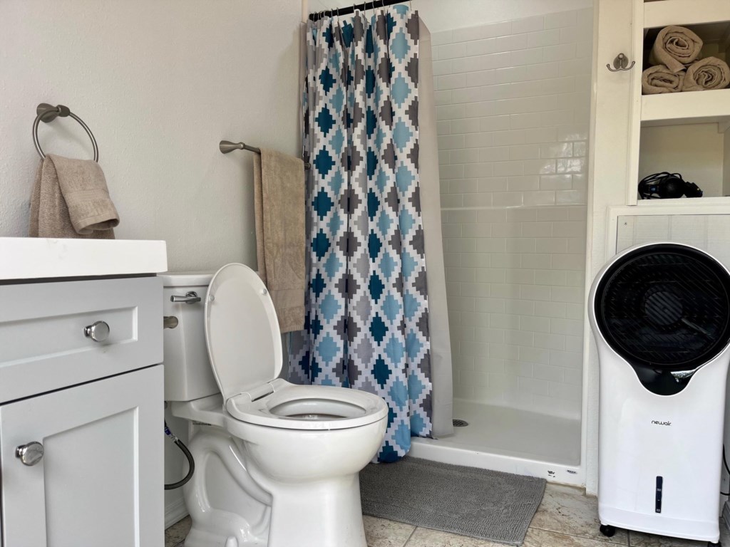 Bathroom offers walk-in shower, toilet & cabinet sink.