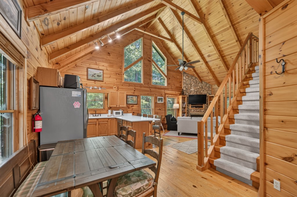 Charming cabin-style living area with vaulted ceilings and cozy stone fireplace.