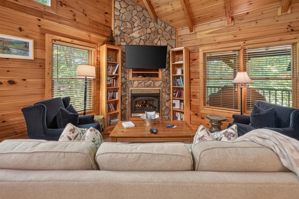 Cozy living room with stone fireplace, plush seating, and warm wood accents.