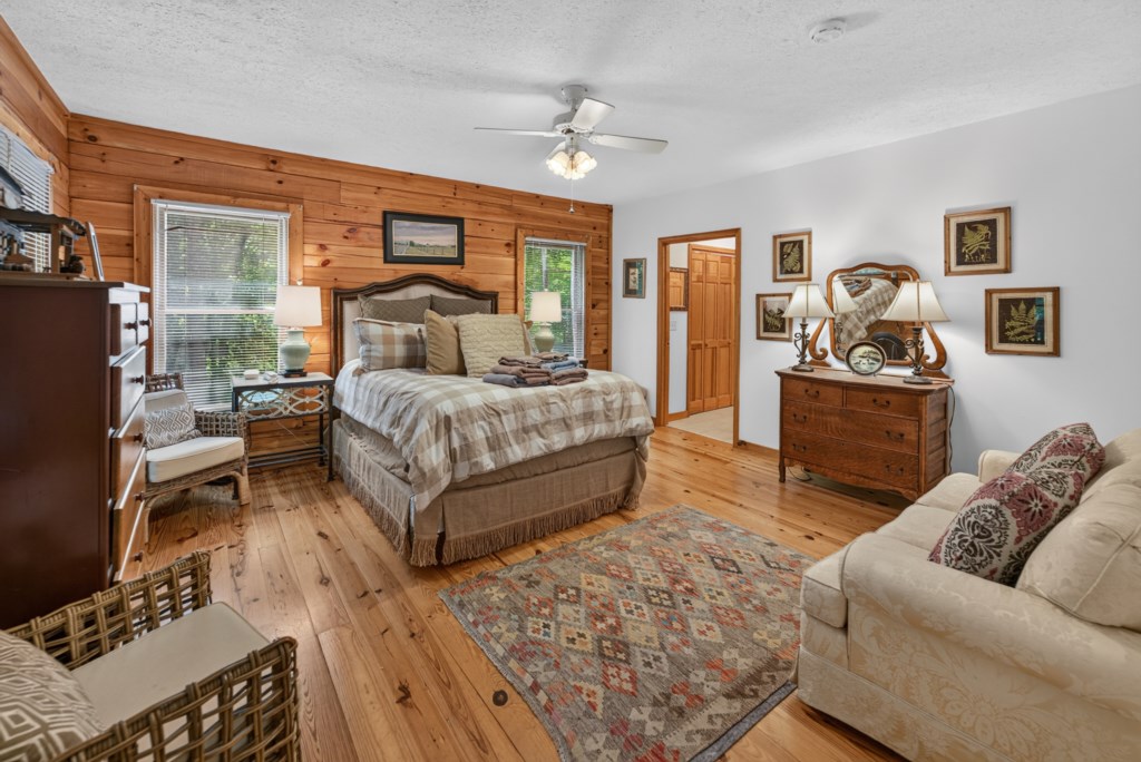 Rustic and inviting bedroom with cozy seating area and natural wood accents.