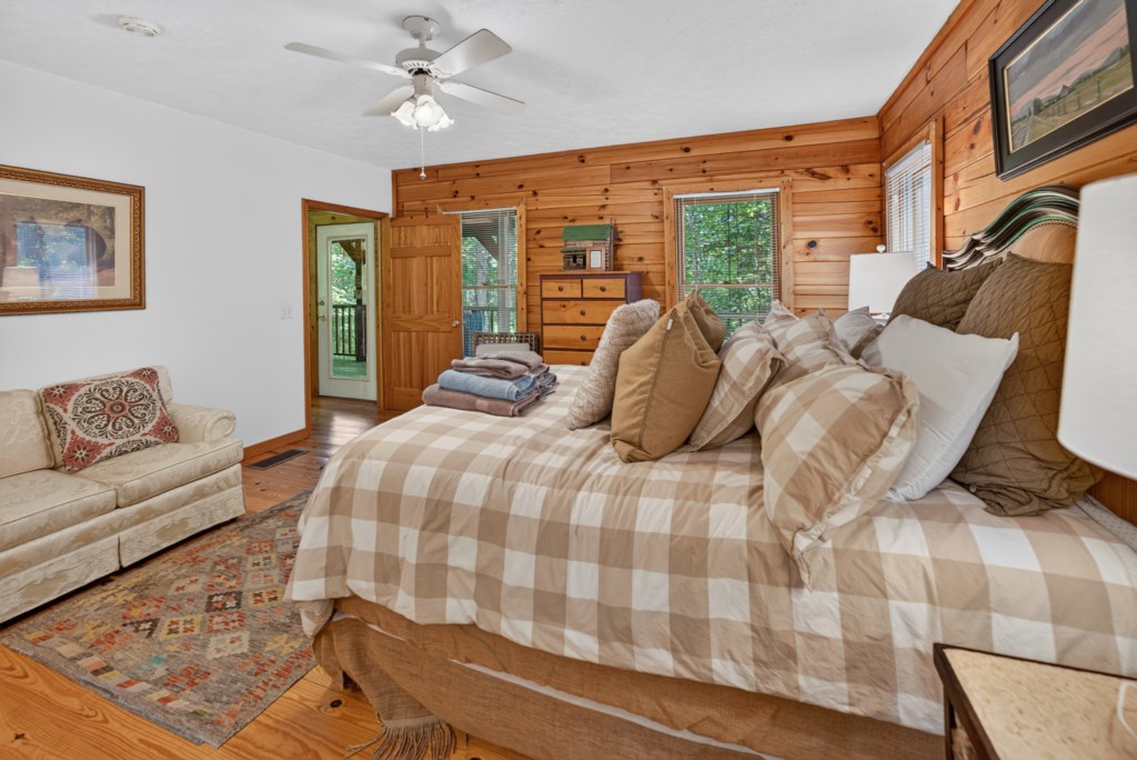 Cozy bedroom with rustic wood paneling and a comfortable plaid bedspread.