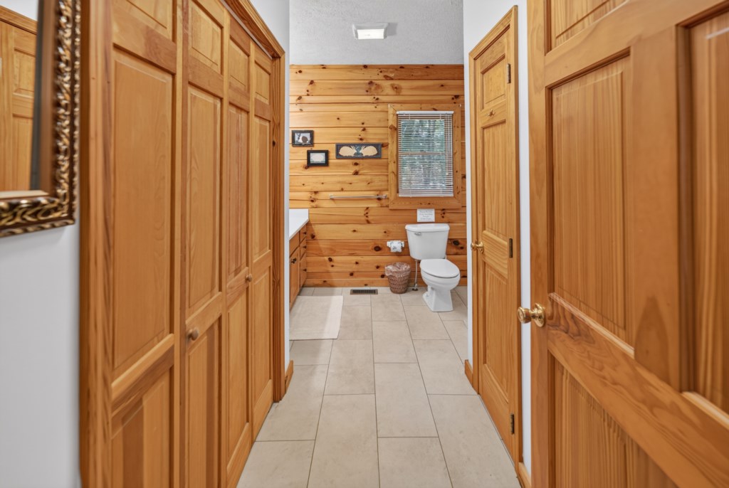 Charming bathroom with rustic wood paneling and ample storage.