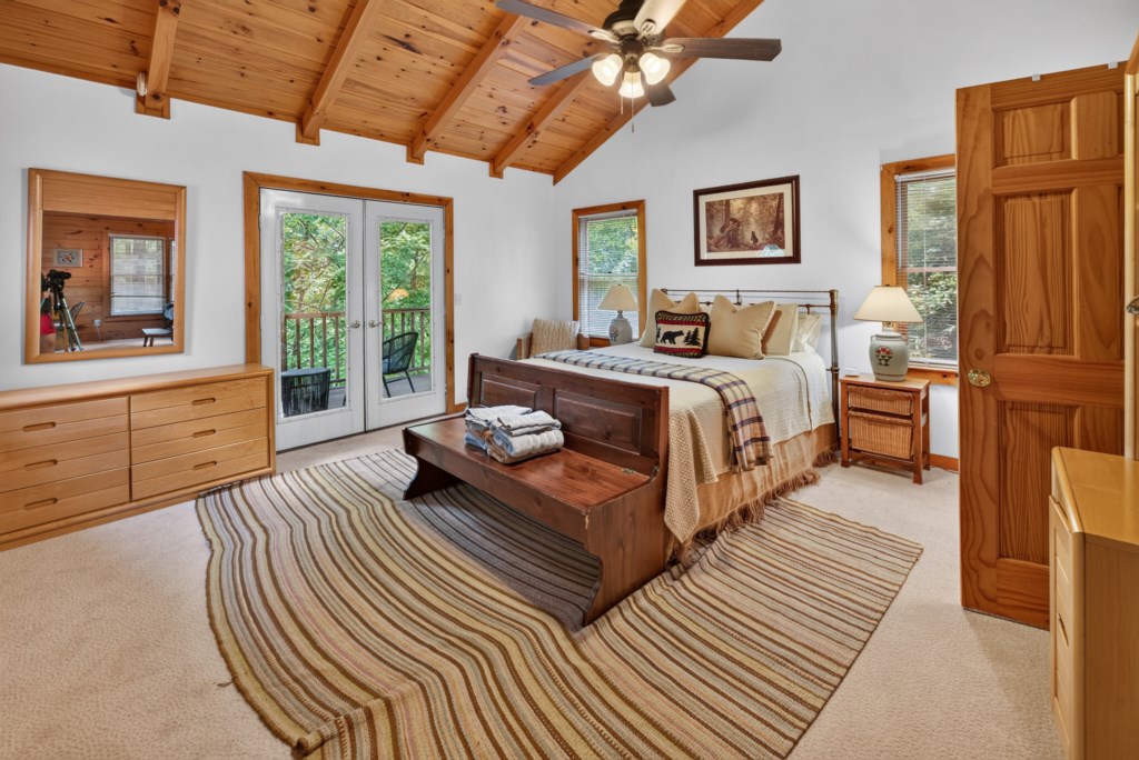 Rustic bedroom with vaulted ceiling and private balcony access for a serene retreat.