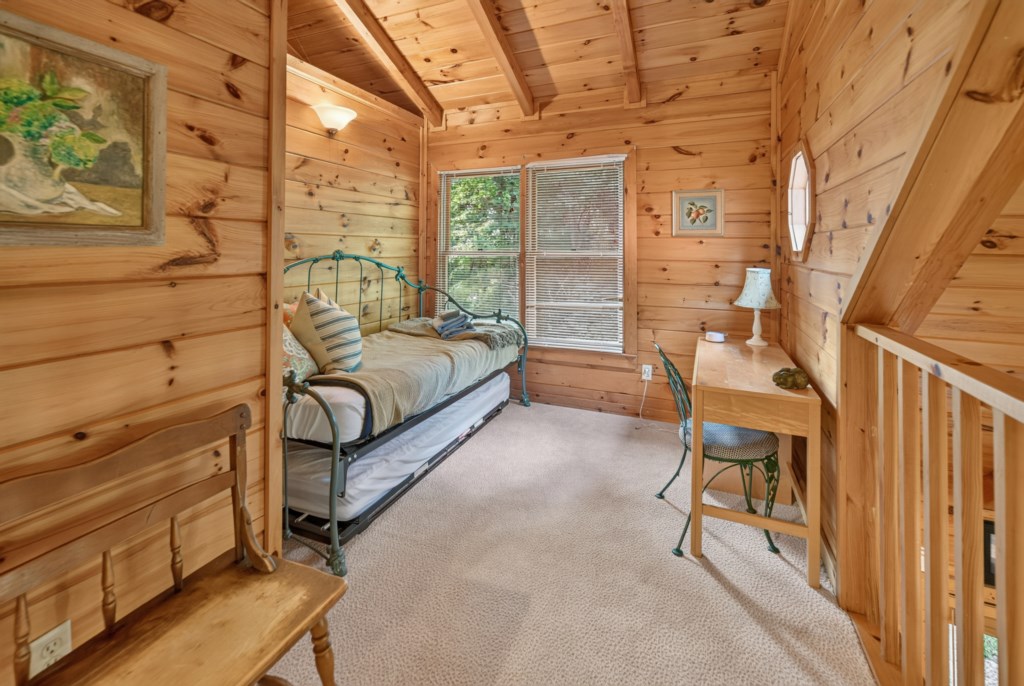 Cozy loft nook with daybed and writing desk, perfect for relaxation or reading.