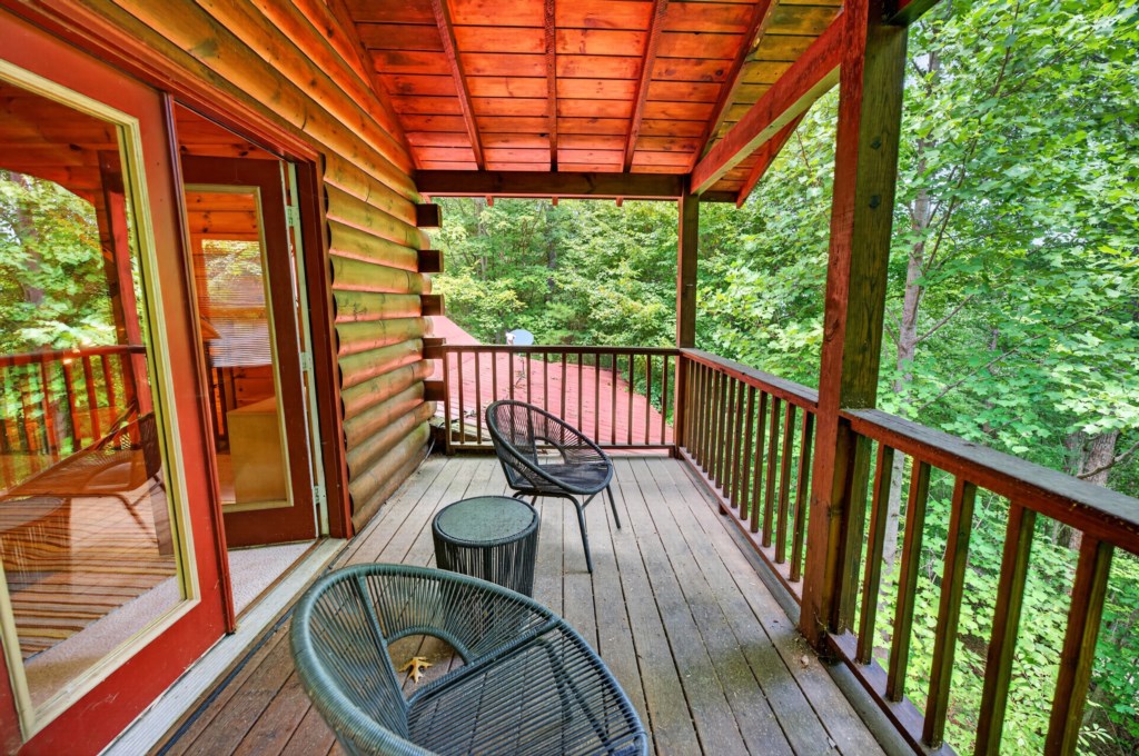 Charming covered deck with forest views, perfect for relaxing with a morning coffee.