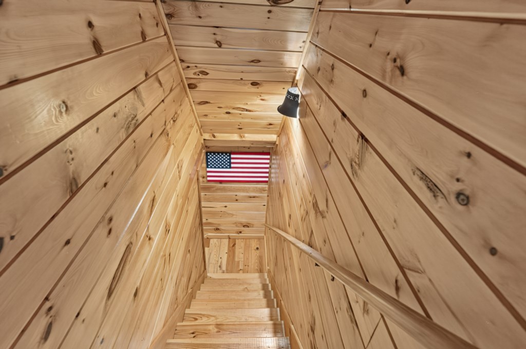 Rustic wooden staircase with charming cabin ambiance and patriotic decor.
