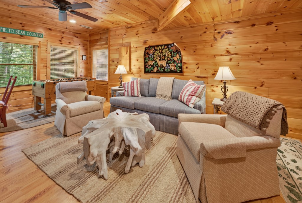 Cozy cabin living room with rustic decor and a foosball table for entertainment.