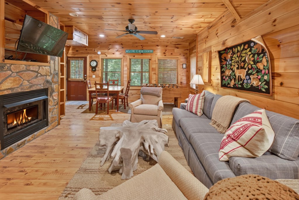 Cozy cabin living room with a stone fireplace and rustic decor, perfect for relaxing evenings.