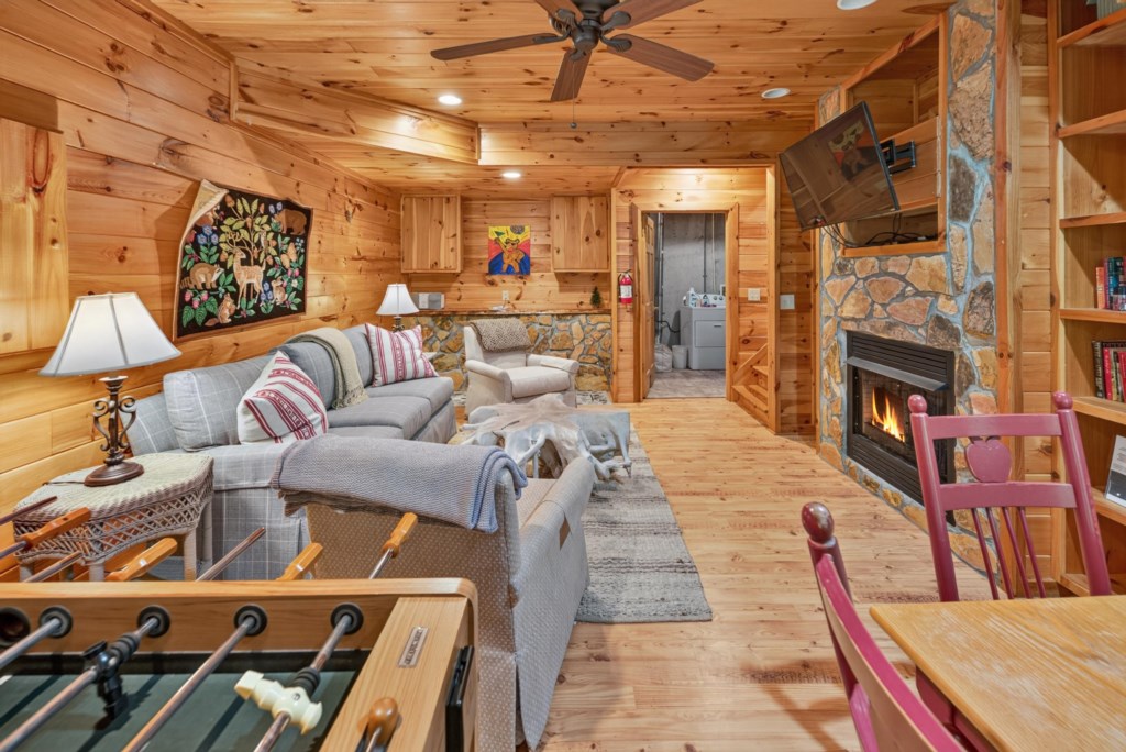 Cozy cabin living room with fireplace, foosball table, and rustic decor for a relaxing retreat.