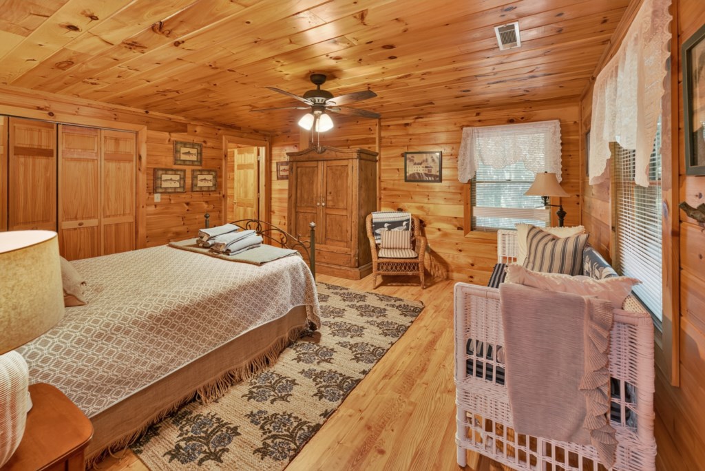 Rustic bedroom with cozy wood paneling and a comfortable seating area.