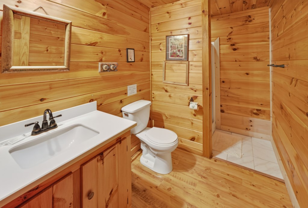 Rustic bathroom with wood paneling and a walk-in shower.