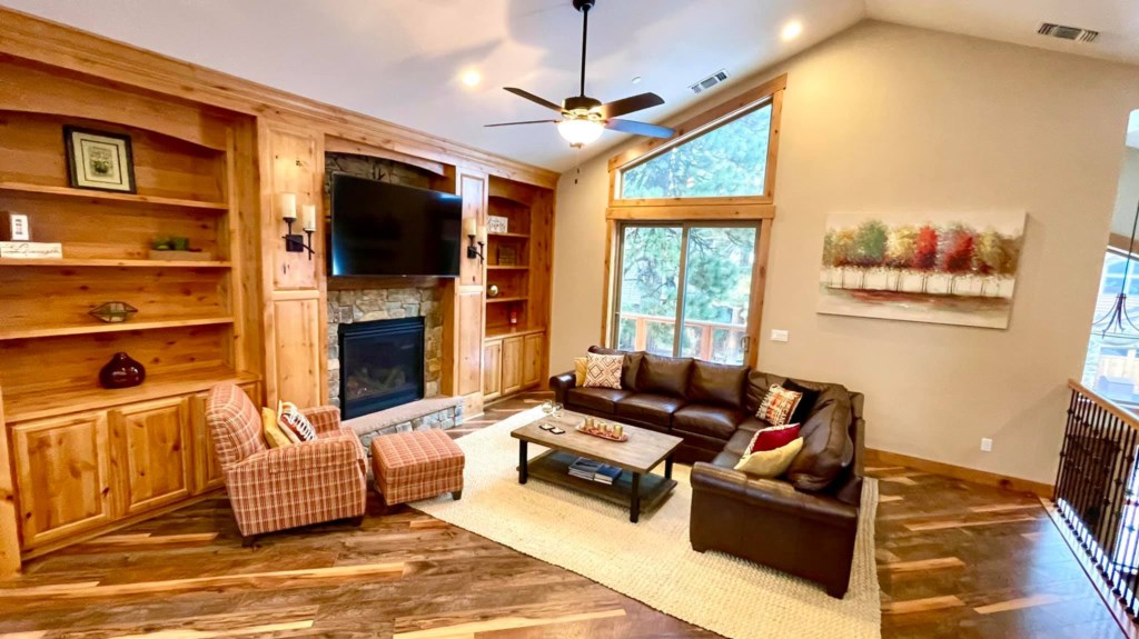 The Living room has plenty of seating options placed in front of a gorgeous stone fireplace