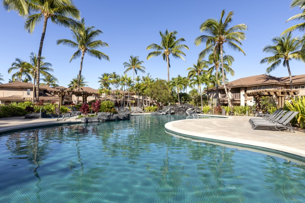 Tropical pool oasis with lush landscaping and plenty of loungers for relaxation.
