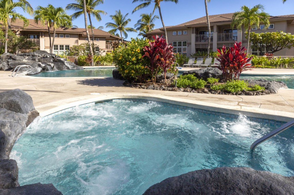 Relaxing hot tub and pool surrounded by lush tropical landscaping.