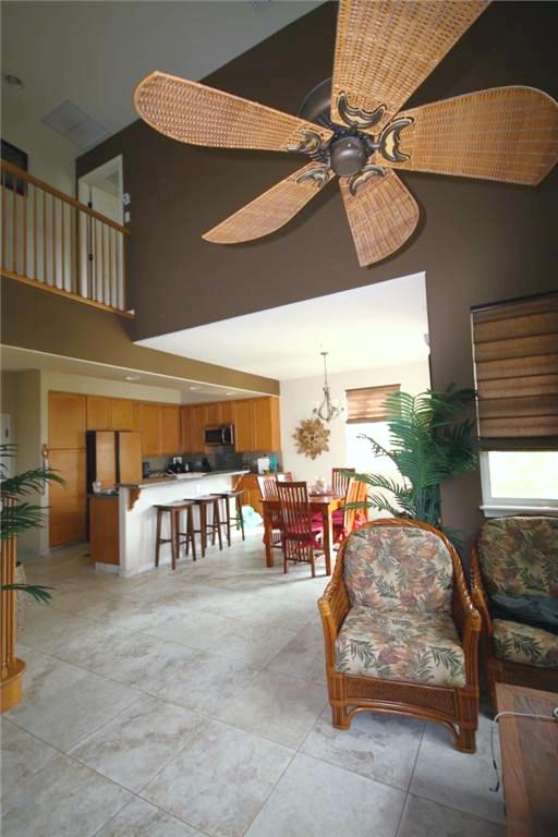 Open-plan living area with a kitchen, dining space, and cozy seating under a ceiling fan.