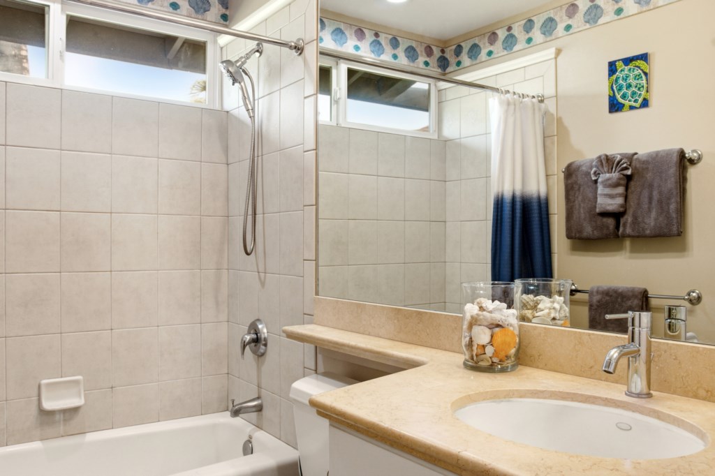 Modern bathroom with elegant tile, spacious vanity, and coastal decor accents.