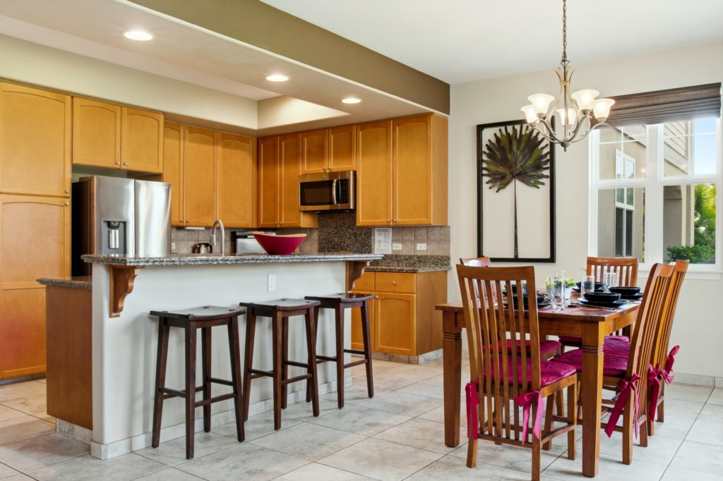 Modern kitchen with breakfast bar and dining area, perfect for family gatherings.