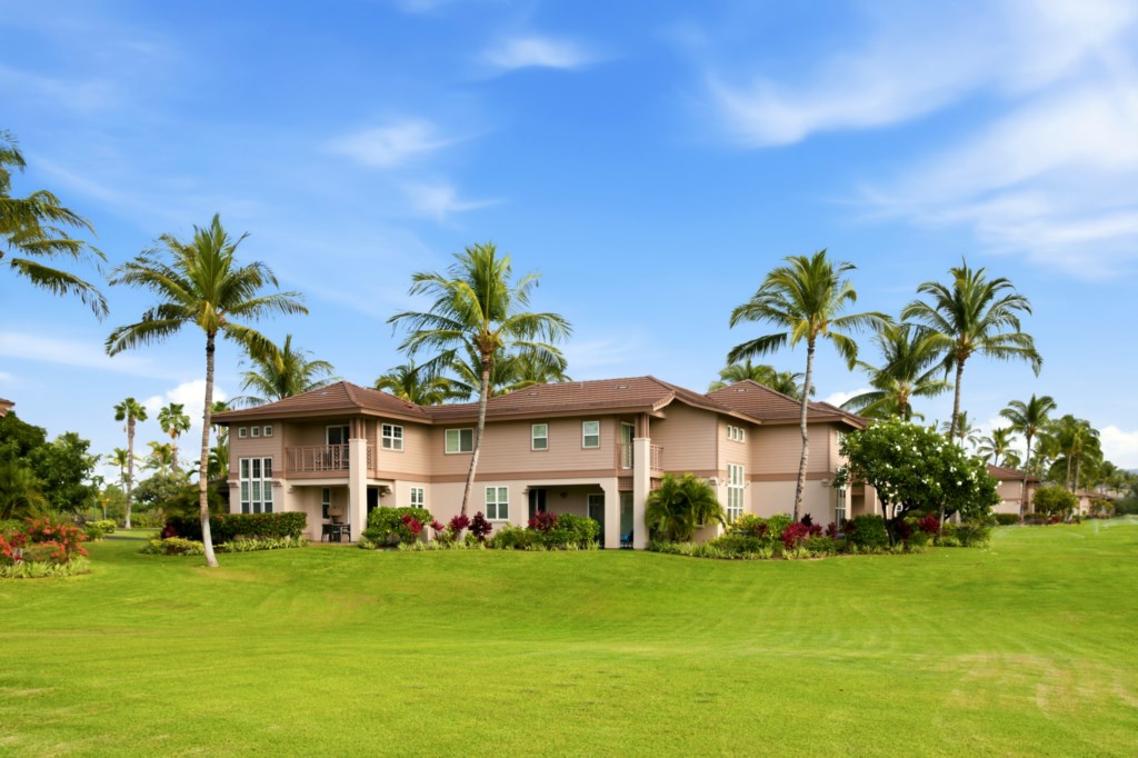 Spacious villa surrounded by lush greenery and palm trees, perfect for a tropical getaway.