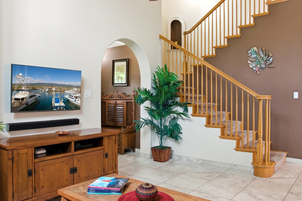 Inviting living area with a flat-screen TV and elegant staircase, perfect for relaxing evenings.