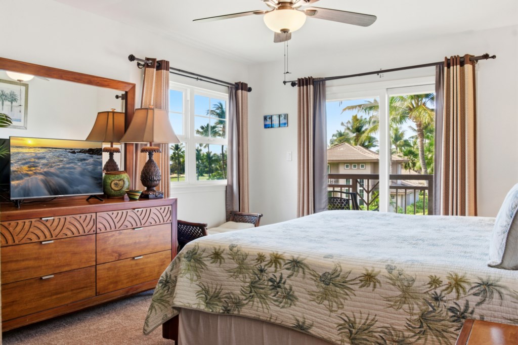 Tropical-themed bedroom with balcony access and garden views.