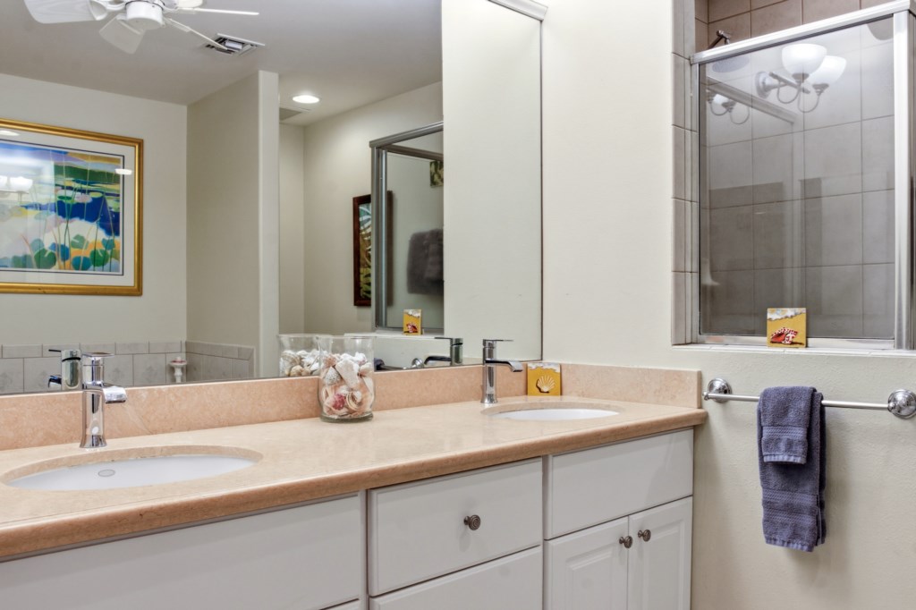 Modern bathroom with double sinks and spacious shower for a relaxing experience.