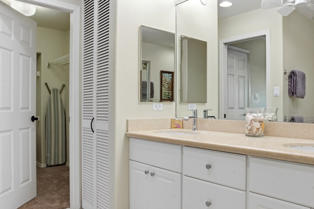 Spacious bathroom with dual sinks and ample storage space.
