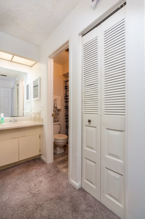 The bathroom with a closet and shower
