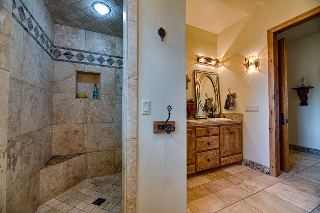Stone Walk-In Shower and Beautiful Mirrors 