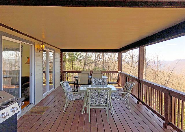 Large Deck is accessed from the Family Room and Main Level Bedroom, has 2 dining tables with comfy seating, gas grill
