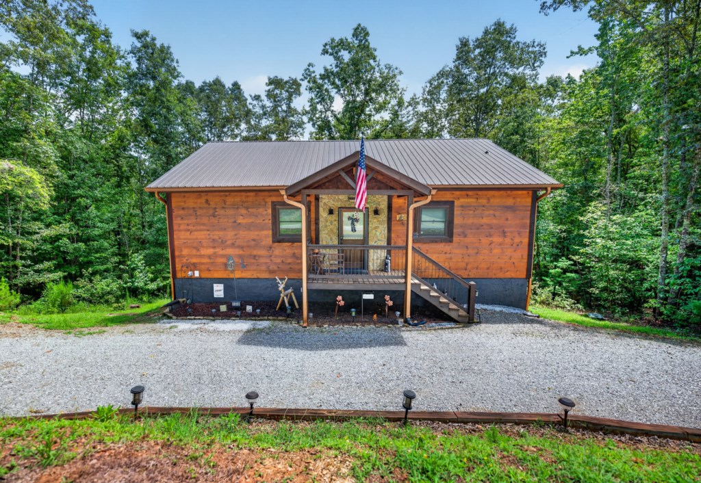 Charming cabin retreat nestled in the woods with a welcoming front porch.