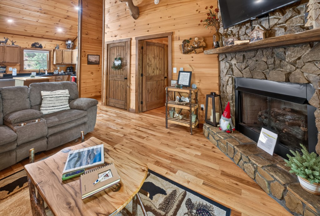 Cozy living room with stone fireplace and rustic wood accents, perfect for relaxing evenings.