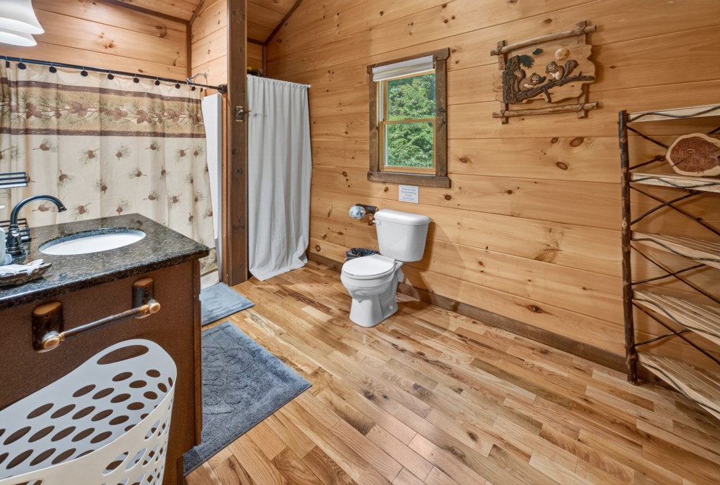Rustic bathroom with wood paneling and nature-themed decor for a cozy cabin feel.