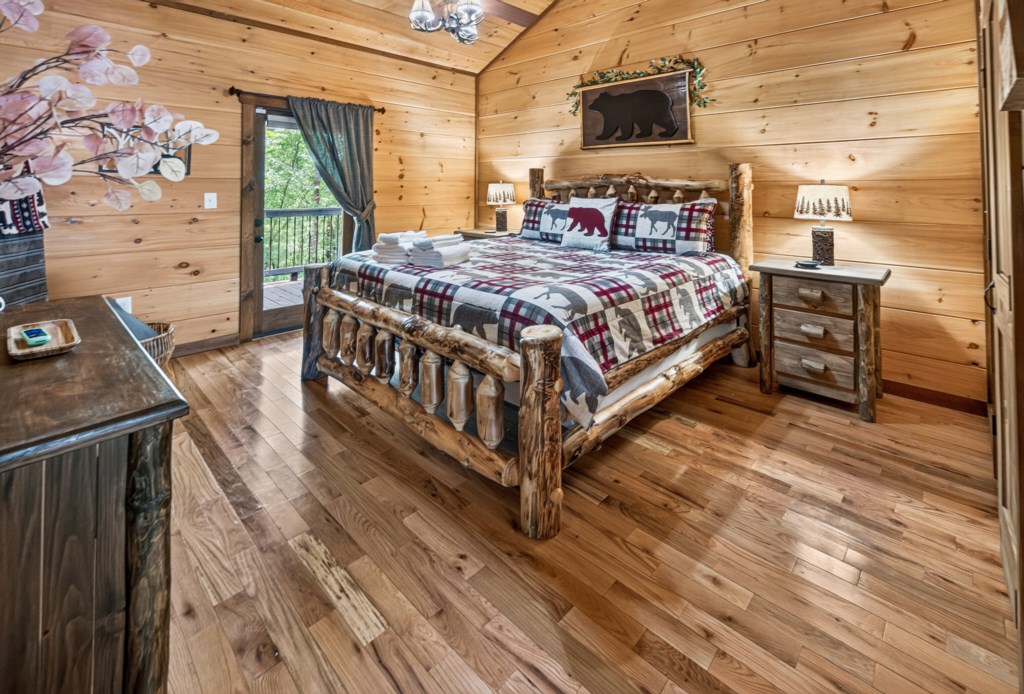 Rustic cabin bedroom with a log bed and private balcony access.