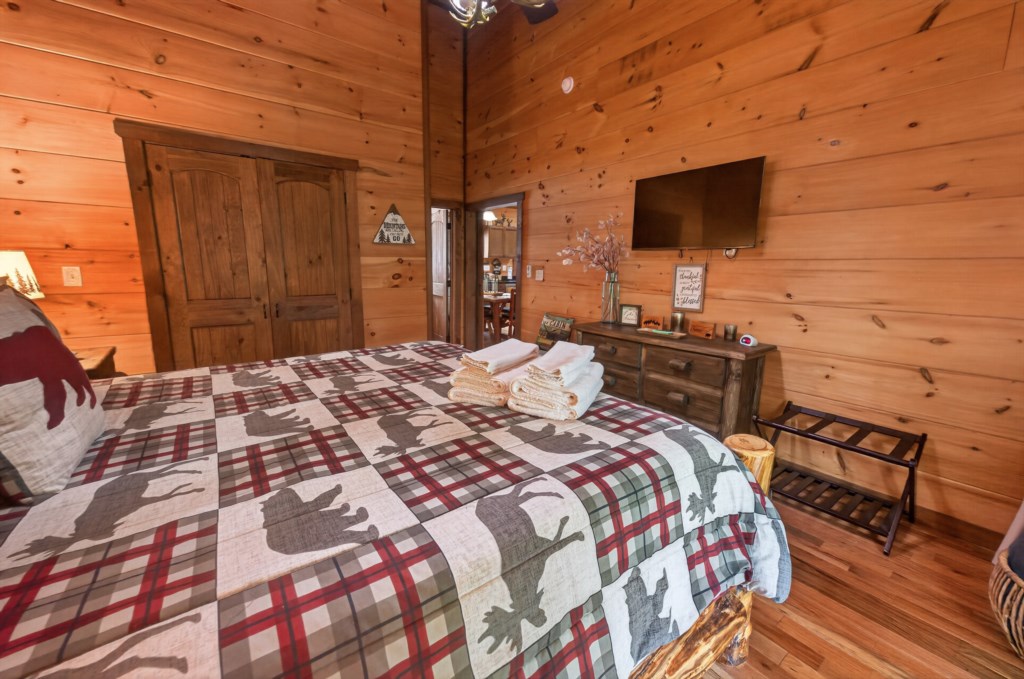 Rustic bedroom with wood paneling and cozy quilt, perfect for a relaxing retreat.