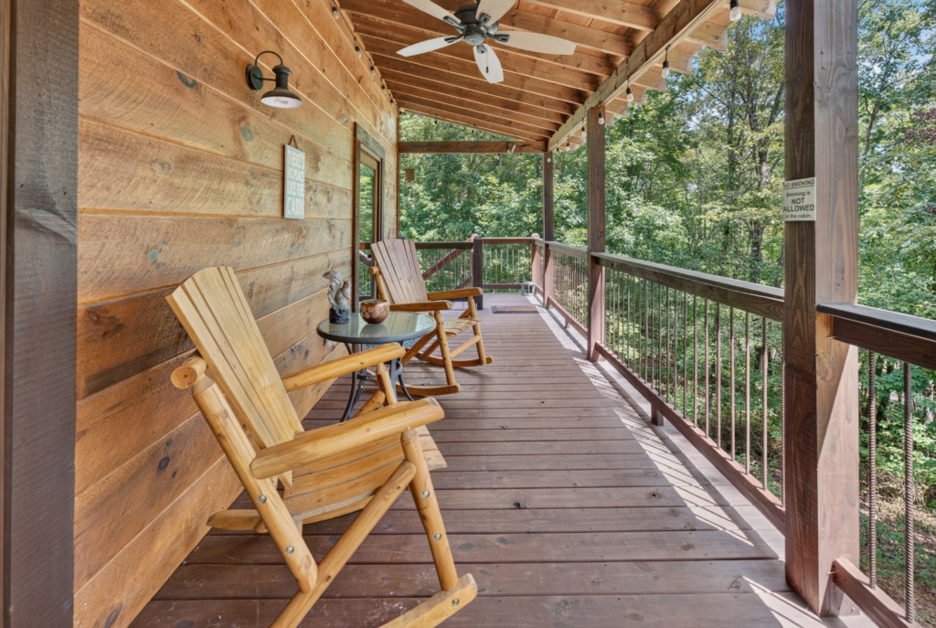 Relax on the rustic porch with rocking chairs and enjoy serene forest views.