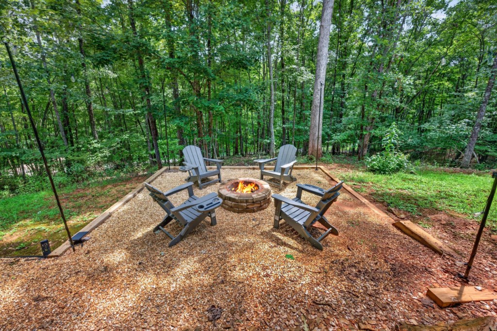 Charming outdoor firepit area with Adirondack chairs, perfect for cozy evenings under the stars.