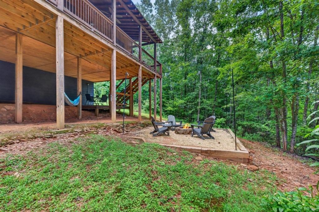 Cozy outdoor firepit area surrounded by lush forest, perfect for evening relaxation.