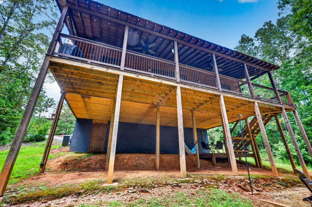 Spacious outdoor deck with hammock, perfect for relaxing in a wooded setting.
