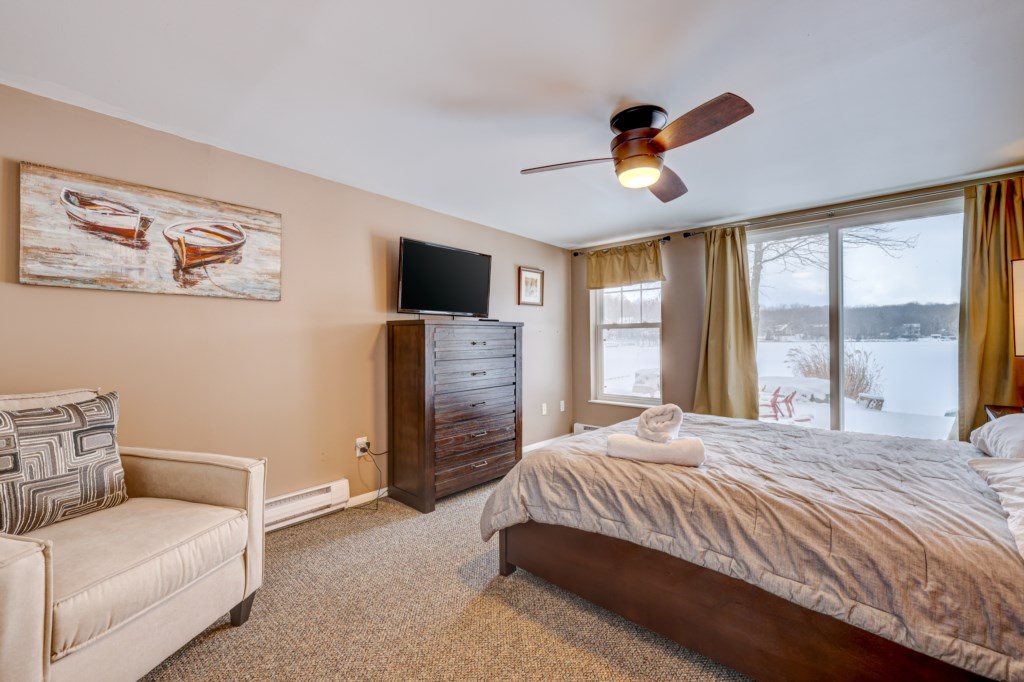 This lakefront bedroom has a sliding door just steps from the lake and fire pit area and large walk-in closet