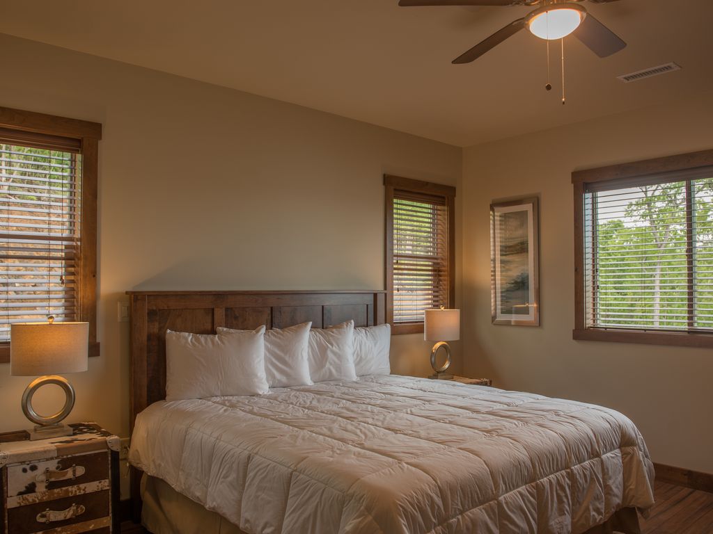 Master suite #1 featuring a king size bed and 40 inch TV with luxury bedding. Equipped with custom made Amish Furniture