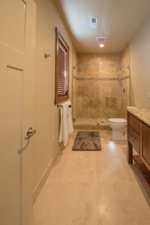 Mater bath #2 featuring a custom natural stone walk-in shower and double vanity.