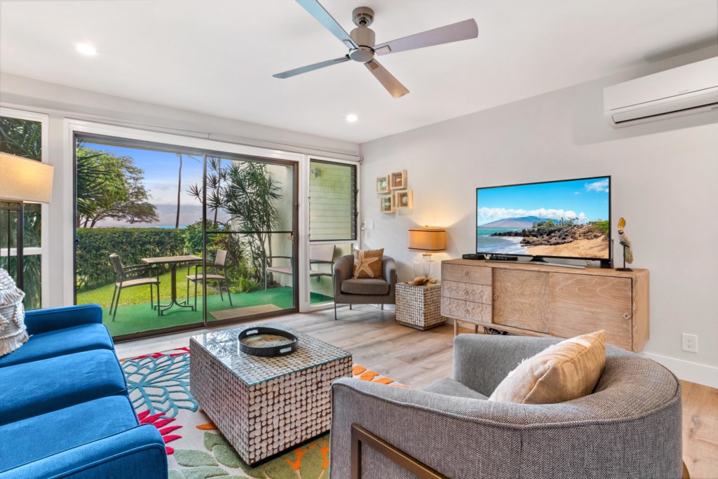 Living Room with large sliding door to lanai, overlooking the ocean, big screen TV and split AC