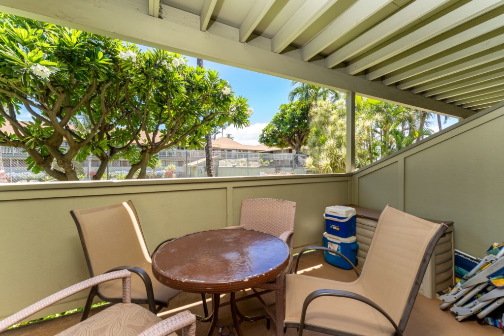 Lanai with outdoor dining seating area overlooking the tennis court