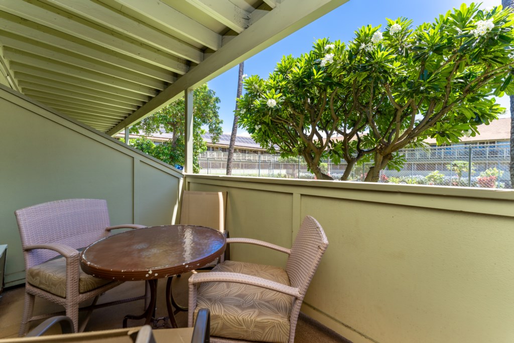 Lanai with outdoor dining seating area overlooking the tennis court