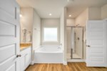 Large attached bathroom with soaking tub and walk-in shower, double vanity, and private water closet