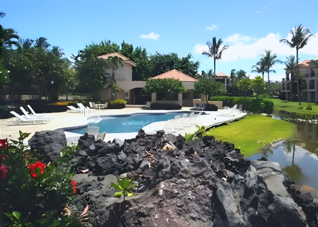 Lounge poolside in a beautiful, tropical setting surrounded by palm trees and lava rock gardens.